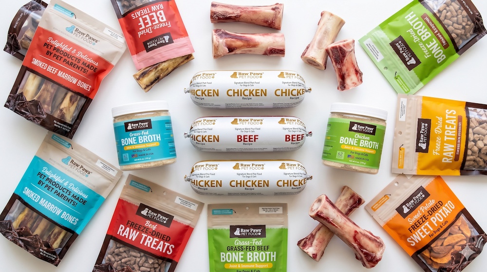 Collection of Raw Paws Pet Food products including frozen meals, chews, bones, and freeze-dried treats arranged together
